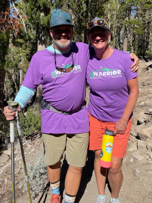 A man and woman hike together on the trail to Mount Rose Summit as part of the Be Warrior Challenge Hike in 2023