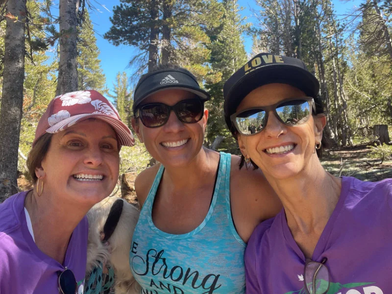Three women hikers pose for a photo on the Mount Rose Summit Trail at the 2023 Be Warrior Challenge Hike